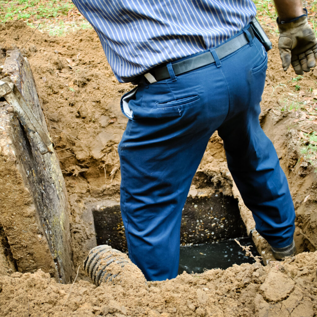 pumping technician opening up a septic tank