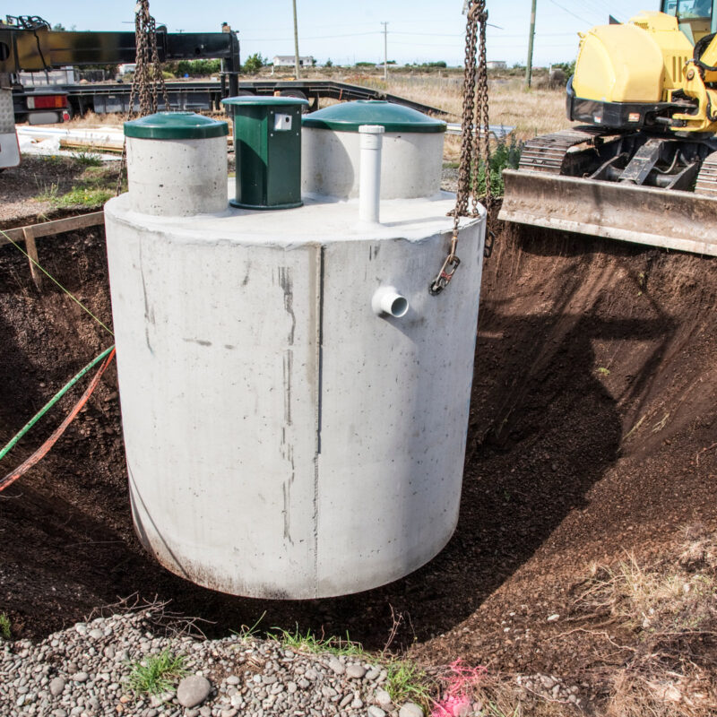 septic tank being lowered into the ground