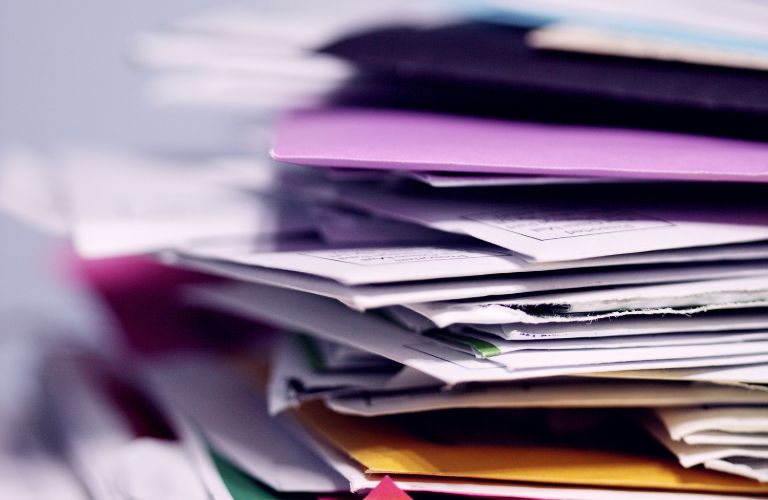 stack of papers piled up with postage markings and envelopes