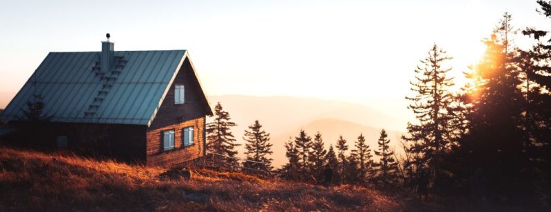 home or cabin high up on mountain with trees and sky in background