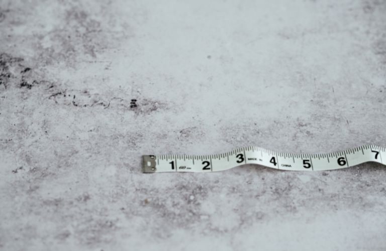 white measuring tape on a granite countertop showing seven inches