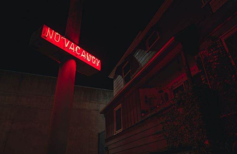 hotel with no vacancy sign lit up in neon red