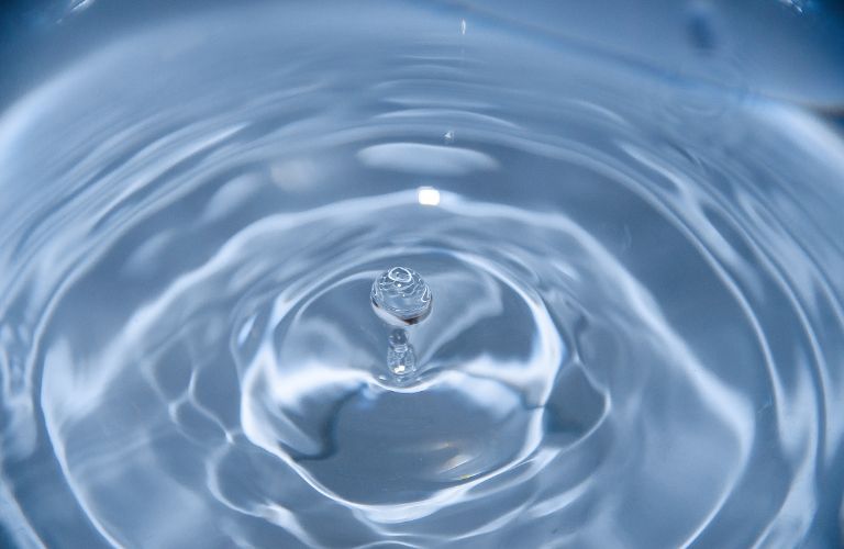 clear blue water with a droplet of water and ripples