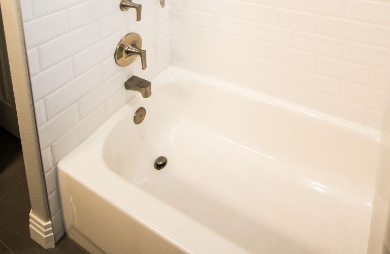 clean tub drain and faucet of white bathing tub