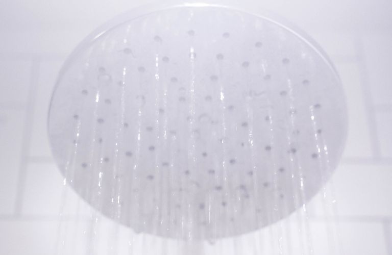 hazy view of shower head with water coming out of it