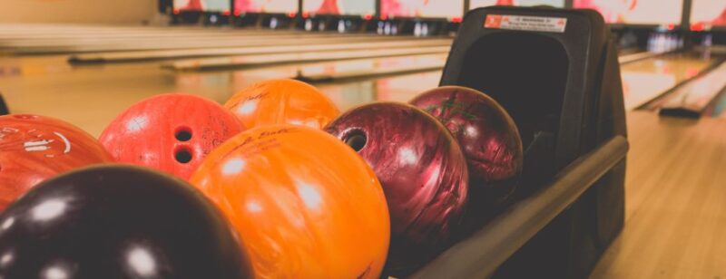 bowling balls lined up in front of lanes