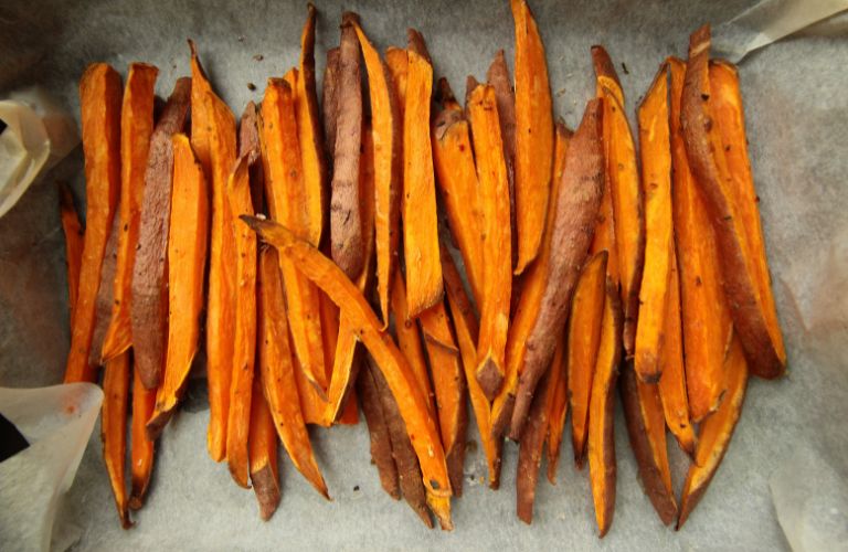 sweet potato fries resting on parchment paper