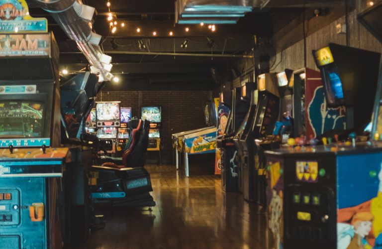 Inside an arcade with machines lined up along the walls