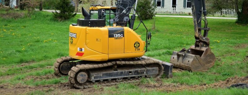 digging equipment parked on grass with dirt exposed