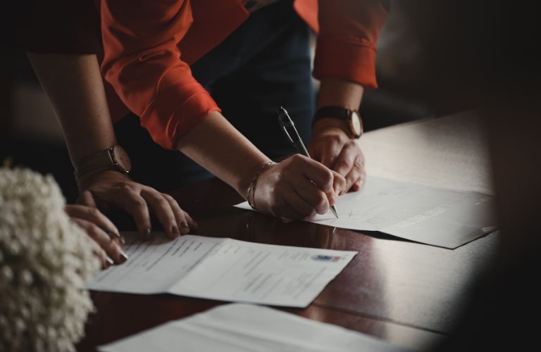 people signing important documents together