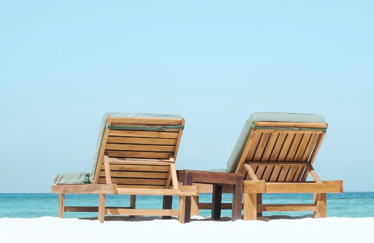 wood reclining chair on a beach looking out to the sea