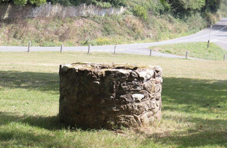old stone well by the side of a road