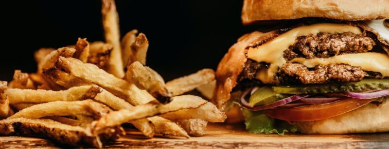 juicy burger and fries on a wood slab