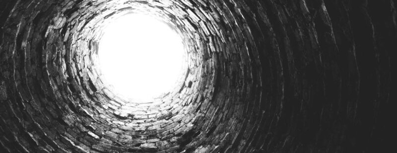 looking up from the bottom of a brick lined well into the light