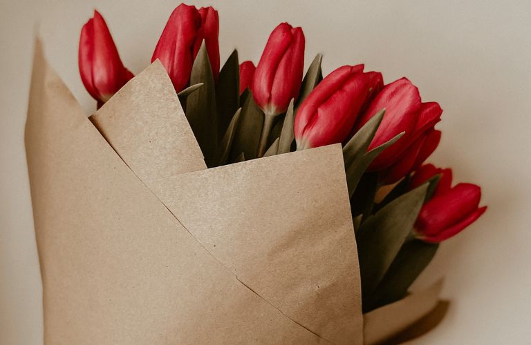 red tulips in a brown paper bouquet
