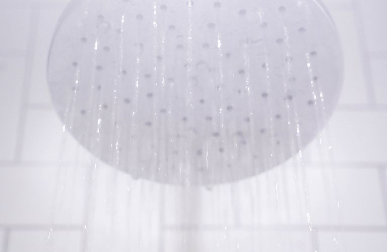 steamy round shower head spraying hot water