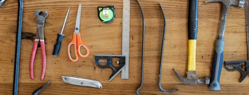 assortment of tools laid out on a wooden worktop