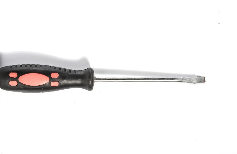 flat bladed screwdriver with black and red handle lying sideways