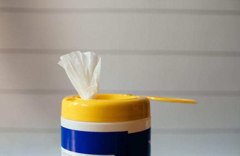 disinfecting wipe in yellow container