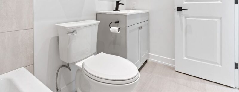 White toilet in a clean white and black bathroom