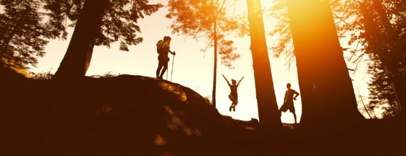 people hiking a hilly trail in the low sun