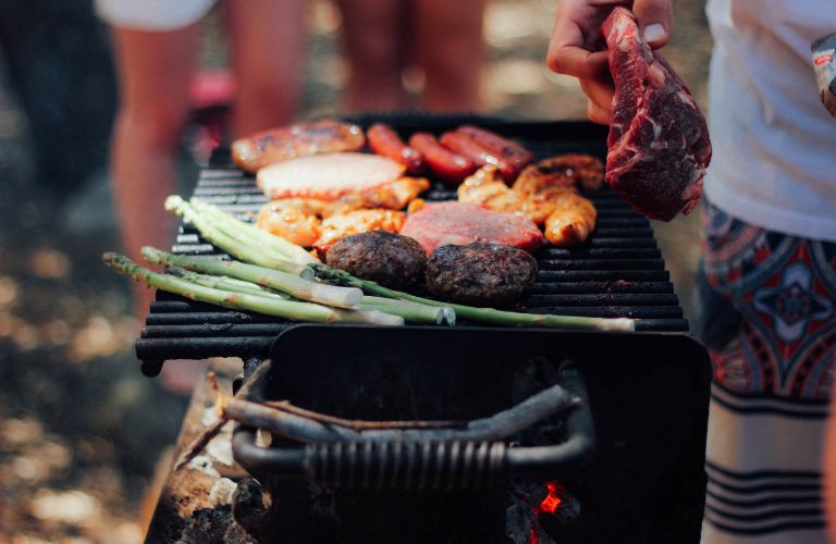 asparagus and meats on an open grill cooking