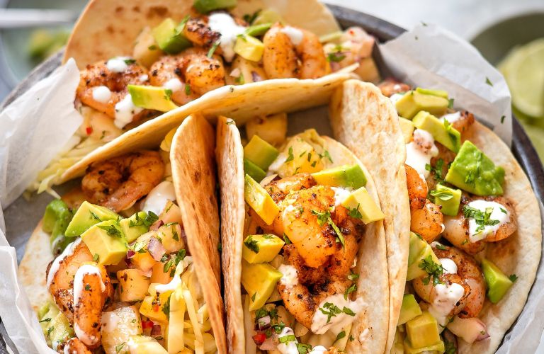 plate of small tacos with meat and fresh vegetables