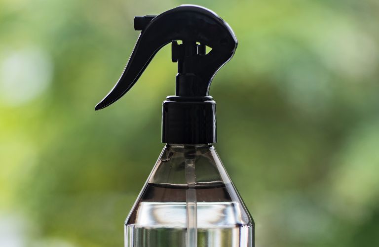 spray bottle in front of a blurry window