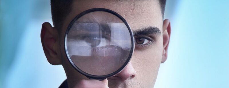 person looking through a magnifying glass to inspect something