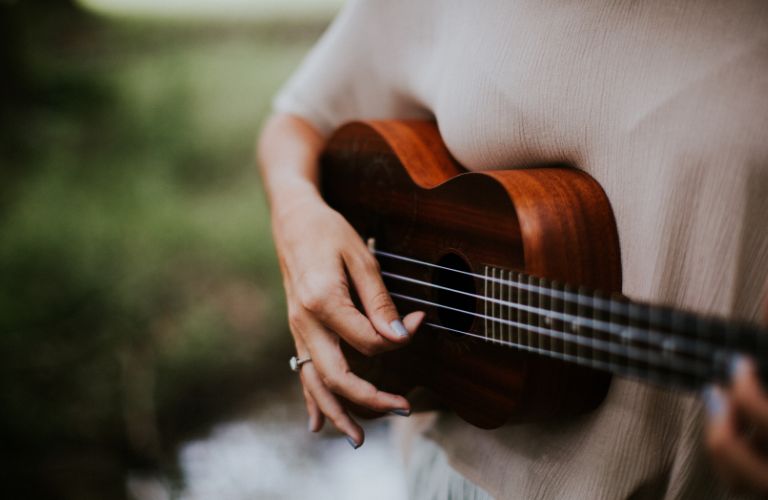 person strumming ukulele