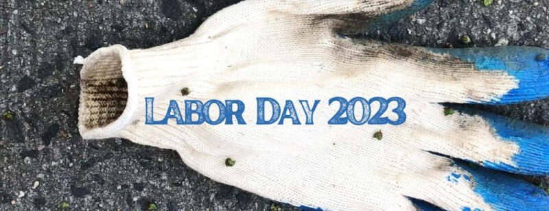 work glove dirty and lying still on concrete with labor day 2023 written over it