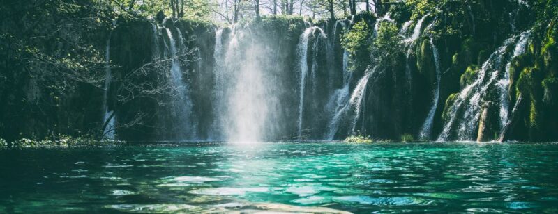 wide waterfall and clear blue water underneath