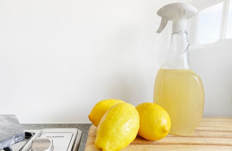 lemon juice in a bottle next to some lemons on a countertop