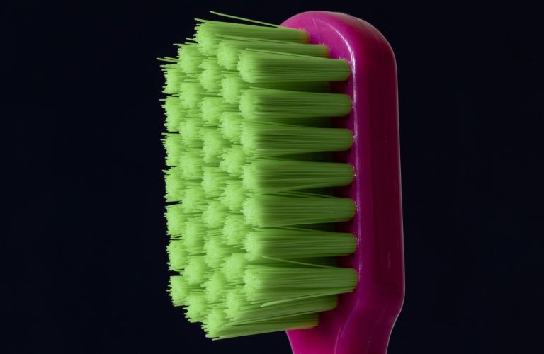 bright green toothbrush bristles set in a purple toothbrush head