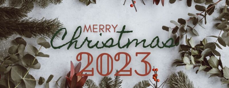 merry Christmas 2023 text with pine branches and ornaments surrounding it