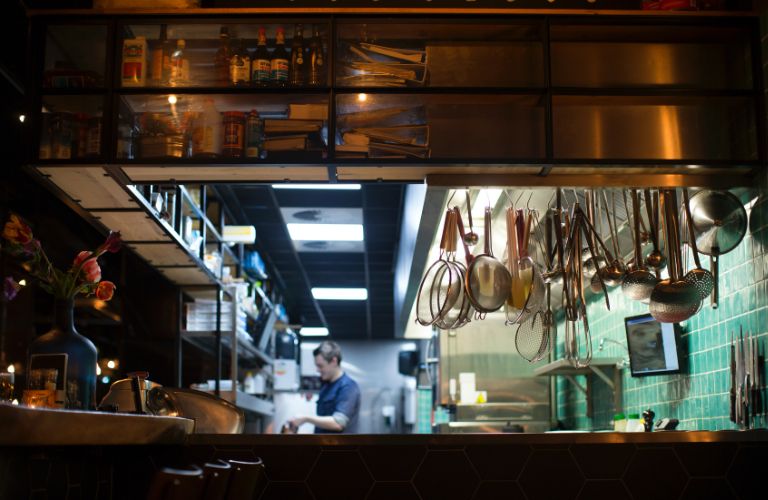 interior of a restaurant kitchen with tools hanging from the walls
