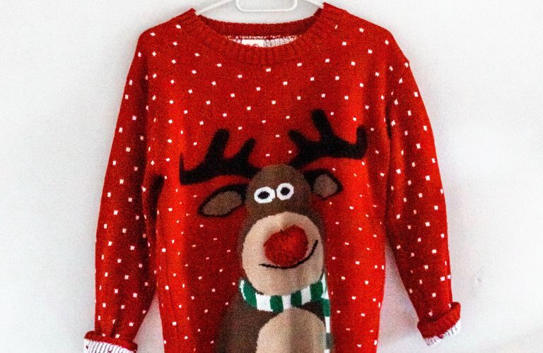 rudolph the red nosed reindeer sweater on a clotheshanger